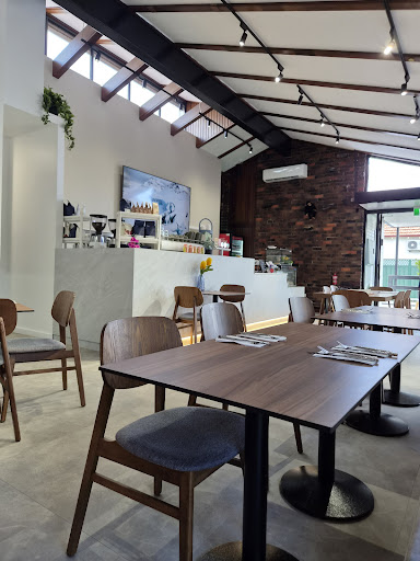 Ricky's interior — timber tables, raked ceiling and natural light