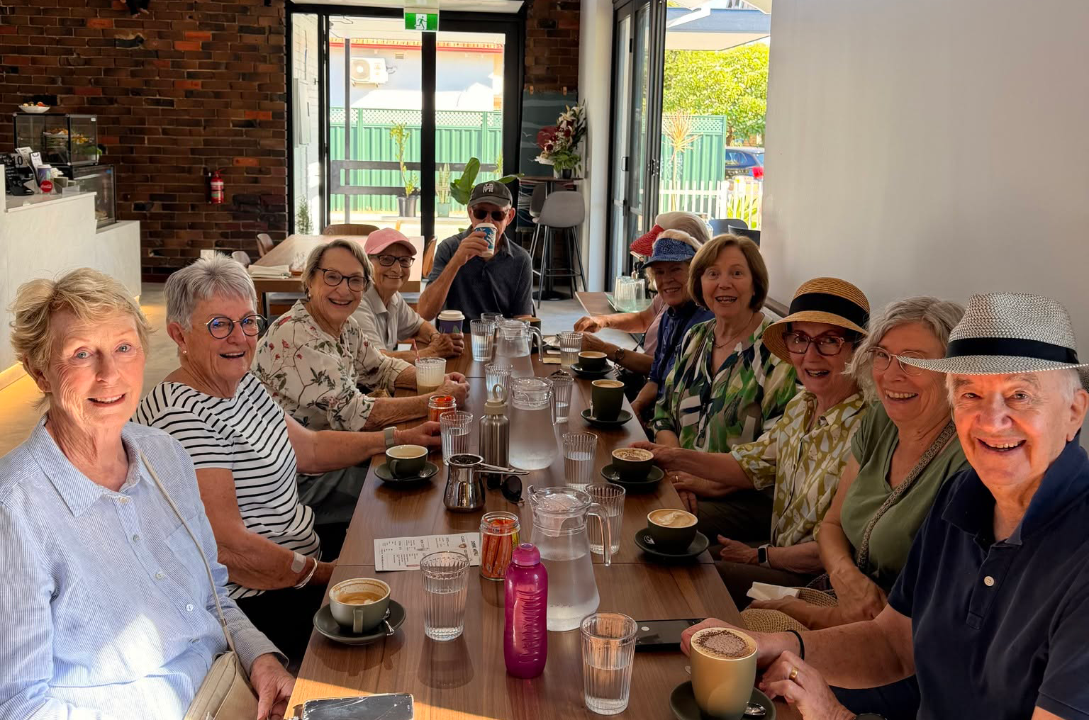 A long communal table of Ricky's regulars enjoying coffee together